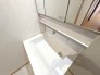 洗面化粧台には、３面鏡のほかに、手をかざすだけでTOPライトを点灯可能！水栓上部は小物類がサッと置ける便利なカウンター付き。
